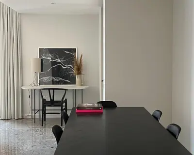 a dining room with a black table and a table and chairs at Fav 2-Bedroom by The Beach in JBR Bahar with stunning Marina View in Dubai