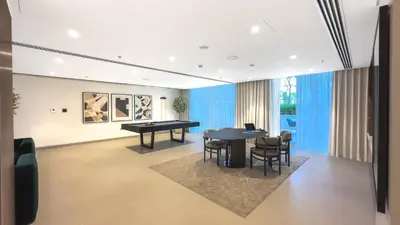 a living room with a ping pong table and chairs at Escape24 Luxury 1BR with Sea View and Beach Access, Dubai Harbour in Dubai