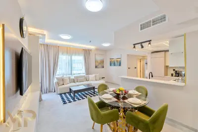 a living room with a table and green chairs at Marcopolo -Enjoy Marina views from a cozy 1BR in Dubai Marina in Dubai