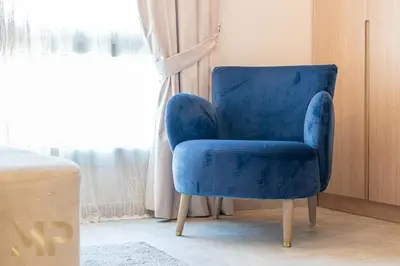 a blue chair sitting in a room with a window at Marcopolo -Enjoy Marina views from a cozy 1BR in Dubai Marina in Dubai