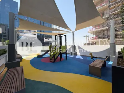 a playground with a slide and benches in a building at Bloomfields Deluxe Studio In Azizi Riviera in Dubai