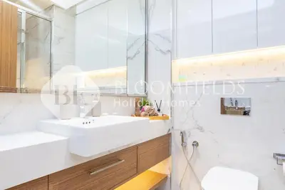 a white bathroom with a sink and a mirror at Bloomfields Deluxe Studio In Azizi Riviera in Dubai