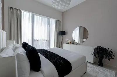a bedroom with a white bed and a mirror at Nasma Luxury Stays - Chic HighRise 1 BR in the Heart of Dubai in Dubai