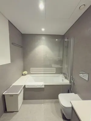 a bathroom with a tub and a toilet and a sink at Nasma Luxury Stays - Chic HighRise 1 BR in the Heart of Dubai in Dubai