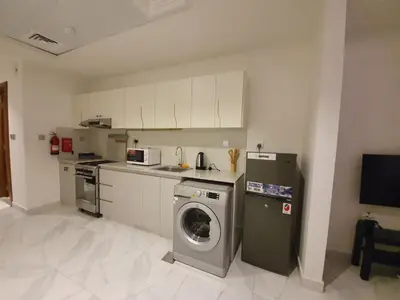 a kitchen with a washing machine and a washer at Millennium Binghatti Residence - Business Bay - Homeyvillas in Dubai
