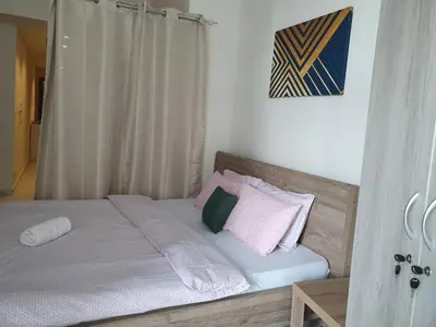 a bed with pink and green pillows in a room at Millennium Binghatti Residence - Business Bay - Homeyvillas in Dubai