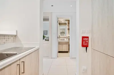 a white kitchen with a red sign on the wall at Seven Palm Residence with stunning view in Dubai
