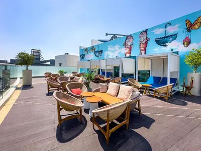 a patio with tables and chairs on a roof at Seven Palm Residence with stunning view in Dubai