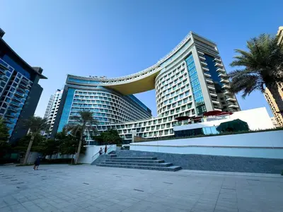 a large building with palm trees in front of it at Seven Palm Residence with stunning view in Dubai