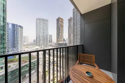 a balcony with a wooden table and a view of a city at Ahad Residences Skyline Studio in Business Bay in Dubai