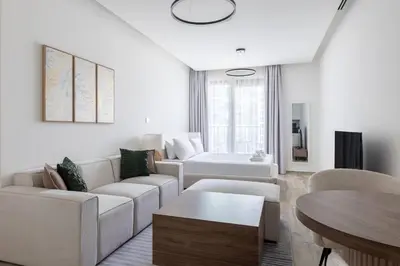 a living room with white furniture and a table at Ahad Residences Skyline Studio in Business Bay in Dubai