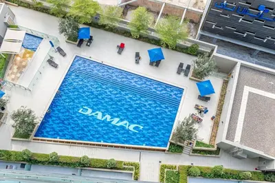 an overhead view of a swimming pool with blue tables and chairs at Lovely 1BR Business Bay near Metro - City Skyline Views in Dubai