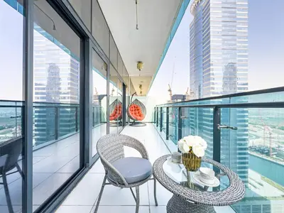 a balcony with a table and chairs on a building at Lovely 1BR Business Bay near Metro - City Skyline Views in Dubai