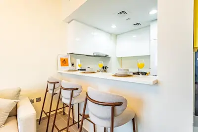 a kitchen with a bar with stools and a counter at Lovely 1BR Business Bay near Metro - City Skyline Views in Dubai