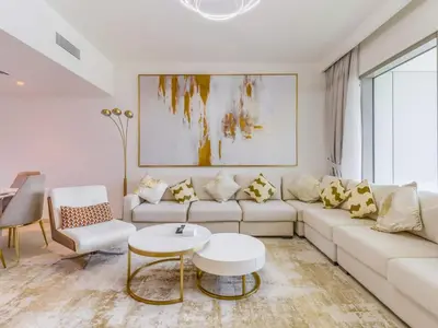 a living room with a white couch and a table at TRPS - Downtown Views II Tower 2, Downtown Dubai - 3BR plus Maids - Burj Khalifa View - Walk to Dubai Mall in Dubai