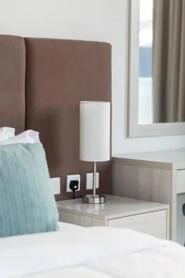 a bedroom with a bed with a lamp and a mirror at Elegant Beachside Studio in Prime Palm Location in Dubai