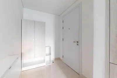 a white hallway with white cabinets and a glass door at Elegant Beachside Studio in Prime Palm Location in Dubai