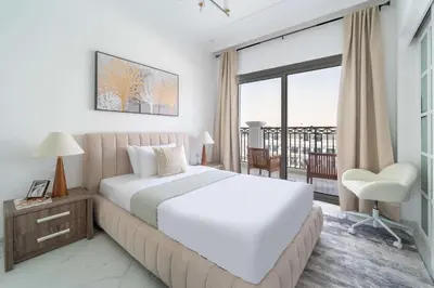 a bedroom with a large white bed and a balcony at Frank Porter - Vincitore Benessere 2 in Dubai