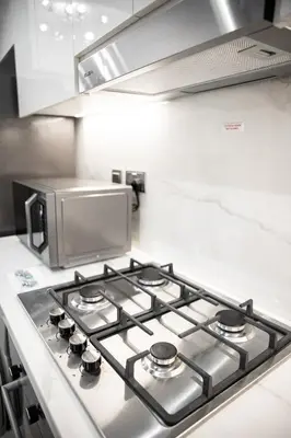 a stove top in a kitchen with a microwave at Stylish 1-Bedroom Apartment with Modern Interior in Dubai