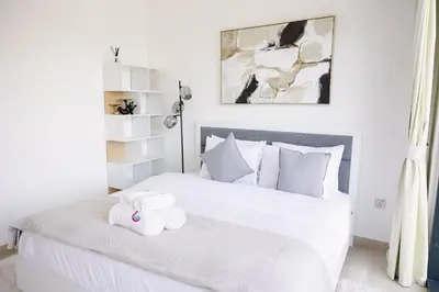 a bedroom with a white bed with two stuffed animals on it at Stylish 1-Bedroom Apartment with Modern Interior in Dubai