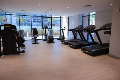 a gym with treadmills and elliptical machines at Stylish 1-Bedroom Apartment with Modern Interior in Dubai