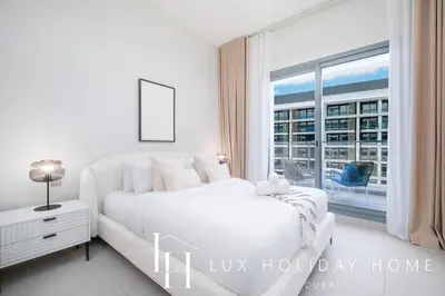 a white bedroom with a bed and a large window at LUX Dubai Hills Sway Studio in Dubai