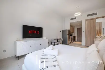 a living room with a tv and a white couch at LUX Dubai Hills Sway Studio in Dubai
