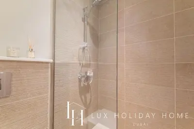 a shower with a glass door with the words lux holiday home at LUX Dubai Hills Sway Studio in Dubai