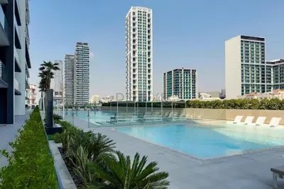 a large swimming pool in a city with tall buildings at Newly Furnished Apartment near Circle Mall with Marina Views, Binghatti Onyx, JVC by Deluxe Holiday Homes in Dubai