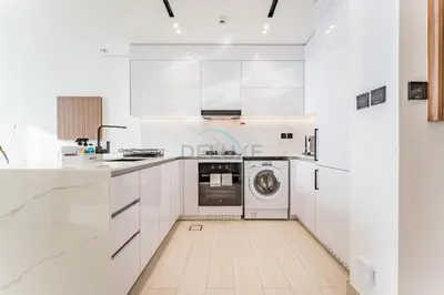 a white kitchen with a washer and dryer at Newly Furnished Apartment near Circle Mall with Marina Views, Binghatti Onyx, JVC by Deluxe Holiday Homes in Dubai