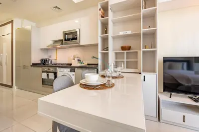 a kitchen with white cabinets and a white counter top at Studio Near Dubai Butterfly Garden, 18 Mins Drive From Mall of Emirates, Miraclz Tower, Arjan By Deluxe Holiday Homes in Dubai