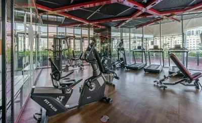 a gym with treadmills and ellipticals in a building at Studio Near Dubai Butterfly Garden, 18 Mins Drive From Mall of Emirates, Miraclz Tower, Arjan By Deluxe Holiday Homes in Dubai