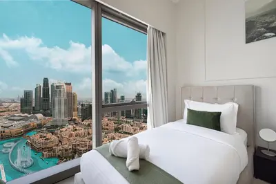 a bedroom with a bed and a large window at Sky-High Luxury 2BR Burj View Walk Dubai Mall in Dubai