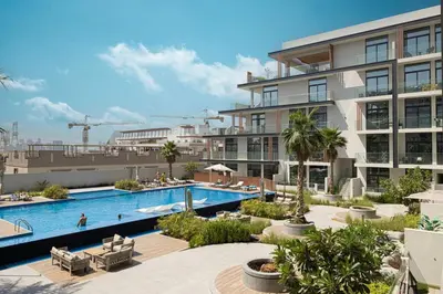 an image of an apartment complex with a swimming pool at Restay Homes - Chic Studio in JVC - Pool Views in Dubai