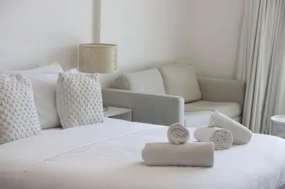 a bedroom with a white bed and a couch at Restay Homes - Chic Studio in JVC - Pool Views in Dubai