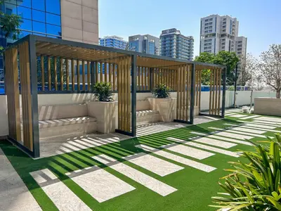 a pavilion with grass and buildings in the background at New 2BR with Jacuzzi and Big Balcony In City Center in Dubai