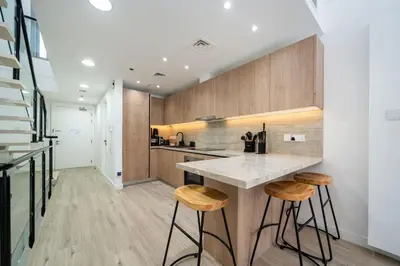 a kitchen with a counter and stools at Luxury JVC 2 Bed Duplex with Private Pool and Jacuzzi in Dubai