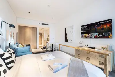 a living room with a large tv on the wall at Elegant Cozy Studio Canal View in Dubai