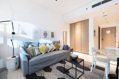 a living room with a couch and a table at Elegant Cozy Studio Canal View in Dubai