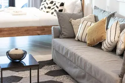 a living room with a couch with pillows and a table at Elegant Cozy Studio Canal View in Dubai