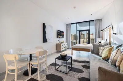 a living room with a couch and a table at Elegant Cozy Studio Canal View in Dubai