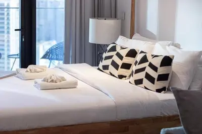 a white bed with pillows and towels on it at Elegant Cozy Studio Canal View in Dubai