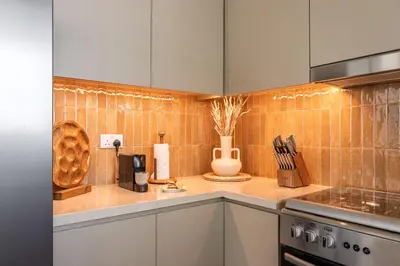 a kitchen with white cabinets and orange tile at Seraya Residences at 52-42 EMAAR in Dubai