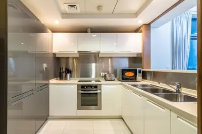 a kitchen with white cabinets and a sink at Modern 2BR in the heart of Downtown Dubai in Dubai