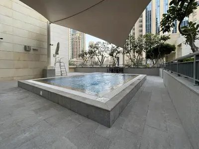 a large swimming pool in a building with an umbrella at Modern 2BR in the heart of Downtown Dubai in Dubai