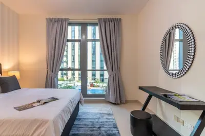 a bedroom with a bed and a large window at Modern 2BR in the heart of Downtown Dubai in Dubai