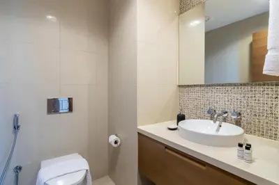 a bathroom with a sink and a toilet and a mirror at Modern 2BR in the heart of Downtown Dubai in Dubai