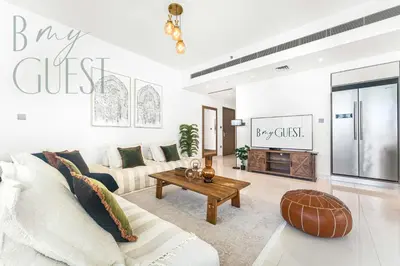 a living room with a couch and a table at Peerless 3BR Beachfront Living in Sunrise Bay in Dubai
