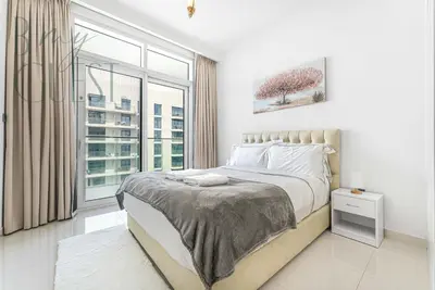 a bedroom with a bed and a large window at Peerless 3BR Beachfront Living in Sunrise Bay in Dubai