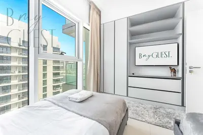 a bedroom with a bed and a window at Peerless 3BR Beachfront Living in Sunrise Bay in Dubai